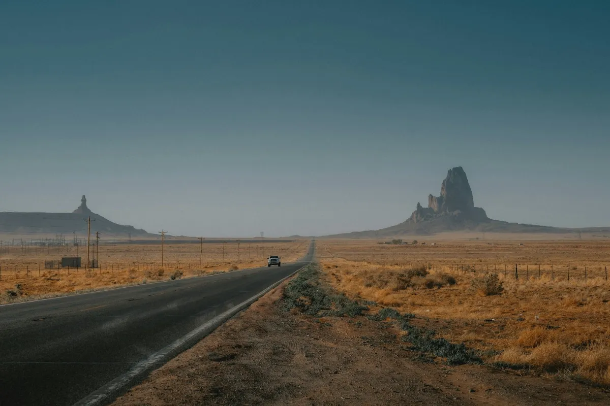 Car driving down a road in the desert