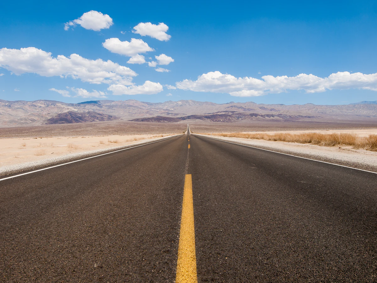Straight road toward distant mountains