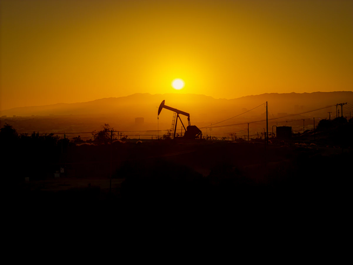 Oil pump jack silhouetted against a sunset
