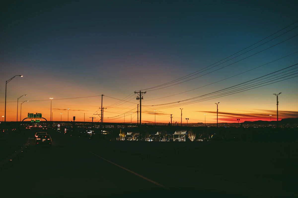 Sunset over a city with power lines