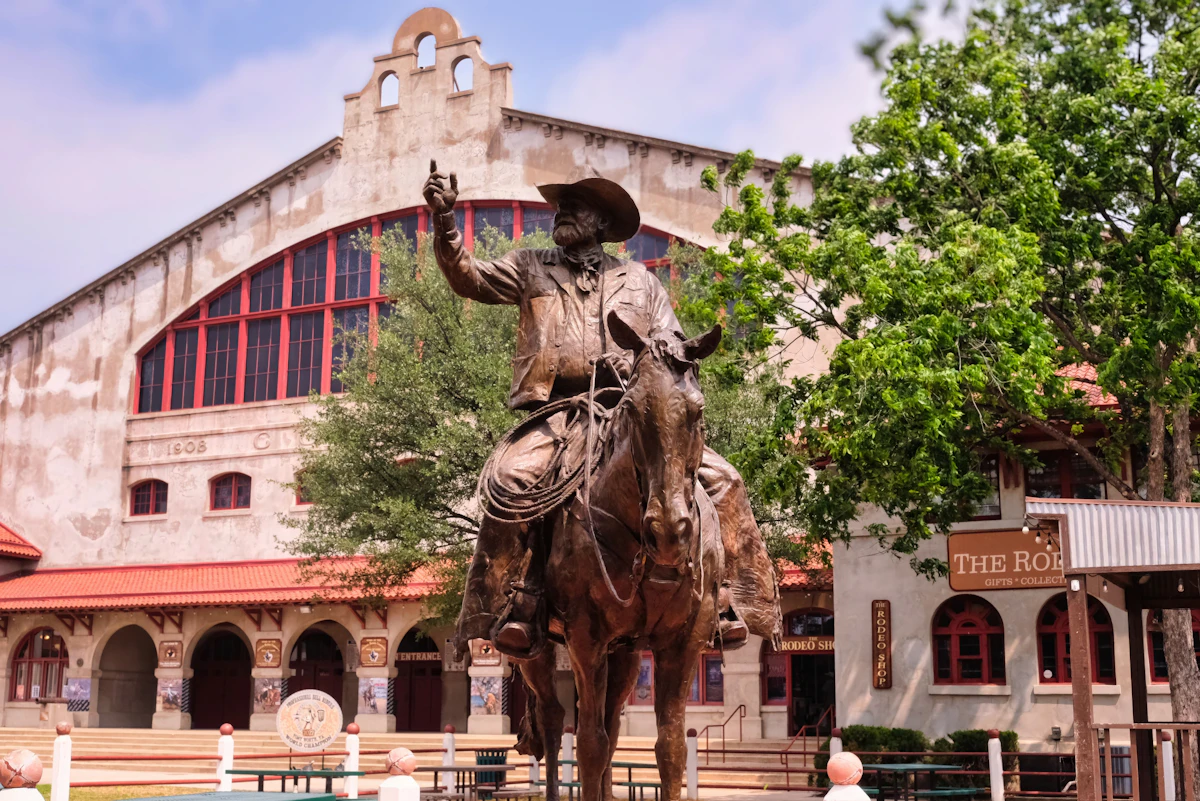 Bronze cowboy statue in front of a historic building